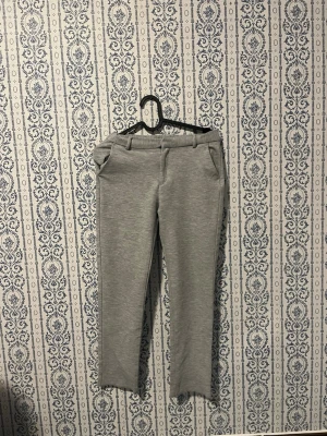 Grå mjukisbyxor från Zara - Gråa mjukisbyxor från Zara med raka ben och fickor på sidorna. Byxorna har resår i midjan och bälteshällor för extra stilpoäng. Perfekta för en chill och avslappnad look.