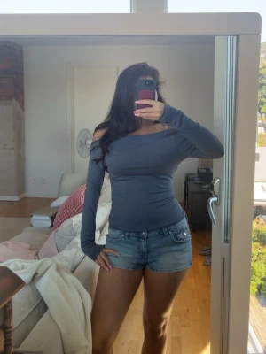 Blå långärmad topp - Säljer en blå, tight och långärmad open back topp. Materialet känns mjukt och stretchigt, vilket gör den bekväm att bära hela dagen.