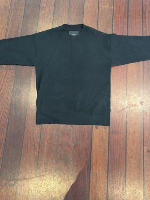 Svart stickad tröja från Jack & Jones - En stilren svart stickad tröja från Jack & Jones med rund halsringning och ribbade muddar. Tröjan har en enkel och klassisk design som passar till det mesta. Perfekt för dig som gillar minimalistisk stil.