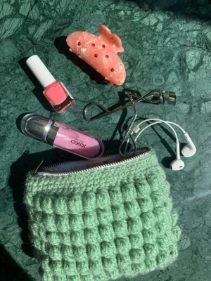 Grön virkad clutch med bubbelmönster - Supersöt handgjord necessär/ clutch-väska i ljusgrönt garn med bubbligt virkmönster. Plånboken har dragkedja och insidan är fodrad med tyg i blommigt mönster. Perfekt för småsaker som smink, hörlurar eller kort. Kan användas som necessär, väska, plånbok och mycket annat. Jättesmart att ha i väskan för att organisera! Kolla Järna in min profil där jag säljer andra färger och storlekar!💞💞