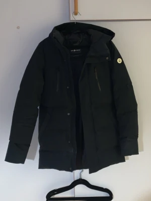 Xs. sail racing vinterjacka  - Säljer Sail racing för har växt ur den passar oxå bra om man har storlek S bra längd och lite bred jacka så passar därför storlek S bra har använt den inte jätte mycket har andra vinterjackor med Max haft på mig den totoslt 17 gånger totalt 5 fickor Snygg svart dunjacka med längre passform och fast huva. Jackan har flera dragkedjeförsedda fickor framtill och en patch på ärmen. Perfekt för kalla vinterdagar tack vare det tjocka dunfodret. Stängs med dragkedja och knappar.