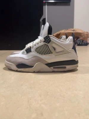 Jordan 4s Military black - Säljer ett par klassiska Air Jordan 4 sneakers i vitt och svart med meshpaneler på sidorna och detaljer i mocka. Skorna har den ikoniska Jumpman-loggan på plösen och en synlig Air-enhet i sulan. Perfekta för dig som gillar streetwear och retrostil. Tveka inte om frågor🙌