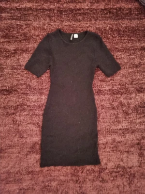 Svart klänning H&M Divided - Svart mellan lång klänning från H&M Divided i storlek S. Enkel och vardaglig med stretch 