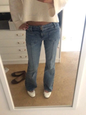 Blå flare jeans med stora fickor - Säljer ett par flare ljusblåa jeans med stora framfickor och markerade sömmar. Jeansen har låg midja 🥰