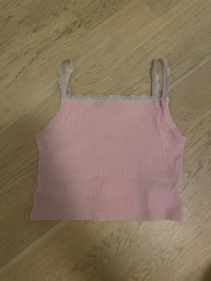 Ljusrosa linne med spets från H&M  - Jag säljer ett ljusrosa linne med spets som är i storlek  134/140.  Det är i ett jätte bra skick och har bara använts några gånger. Jag säljer denna för att den är lite kort för mig och använder den inte! Men det är ett jätte söt linne! OBS! Bra pris!