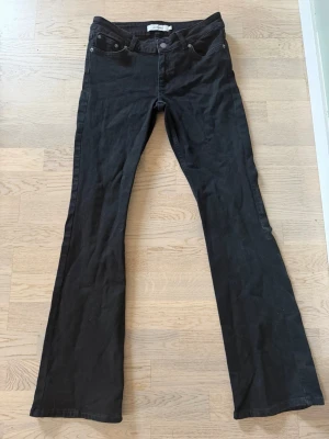Svarta low waist bootcut jeans - Snygga svarta low waist jeans från junkyard som passar till allt. Jeansen används tyvärr inte för dom är korta i benen och dom har inte används mer än en gång:) skriv gärna till mig om ni undrar om måtten. 
