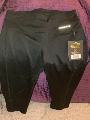 Svarta leggings från Yosemite - Svarta leggings från Yosemite i stretchigt material med hög midja. Perfekta för träning eller chill, med diskret logga framtill. Materialet är mjukt och följsamt för maximal rörelsefrihet.
