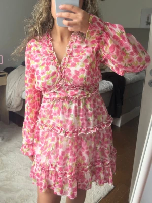 Blommig volangklänning med v-ringning - Supersöt kortklänning med blommigt mönster och långärmad från Vero Moda. Passar perfekt nu till sommaren💕 