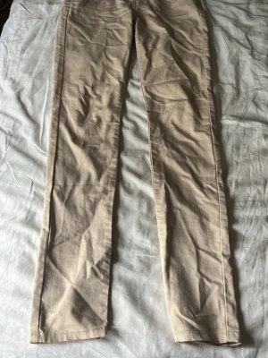 Beige raka jeans/leggins - Säljer ett par beige jeans/leggins med rak passform och klassisk femficksdesign. Jeansen har bälteshällor och är tillverkade i ett mjukt bomullsmaterial med lite stretch. Perfekta för dig som vill ha en clean och enkel look. använd några gånger