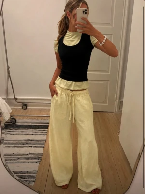 Gula vida mjukisbyxor med dragsko - Snygga och bekväma mjukisbyxor i ljusgul färg med breda ben och dragsko i midjan. Byxorna har en avslappnad passform och är perfekta för en chill och trendig look. Materialet ser mjukt och skönt ut, perfekt för att hänga hemma eller ute med vänner.