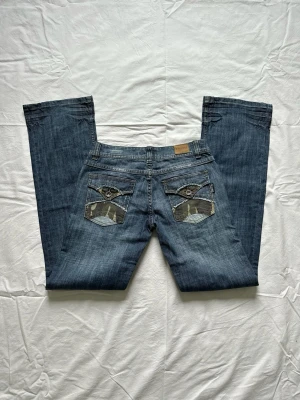 Vintage jeans  - Såååå snygga och unika jeans med militär detaljer och fickor på baksidan.  Midjemått 38 Höftmått 45 Innerbenslängd 83 (På lappen inuti står storlek 28x34) Vid köp av flera varor får du rabatt💛
