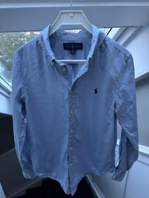 Ljusblå skjorta från Ralph Lauren - Säljer denna otroligt snygga blåa Ralph Lauren skjortan. Storlek 16 i barnstorlek alltså ungefär en xs i herr. Sparsamt använd och inget slitage som syns. Pris 399✅ hör av dig vid minsta fundering //Noel