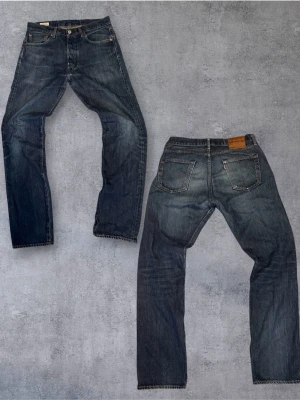 Sjukt nick Levi's 501 straight fit  - Klassiska Levi's 501 jeans i blå denim med raka ben och femficksmodell. Jeansen har knappgylf och detaljer i kopparfärgad metall. Snyggt slitna för en avslappnad look och tillverkade i bomull. Perfekta för dig som gillar tidlös stil. Mått: längd  109cm, midja 41cm benöppning  20cm