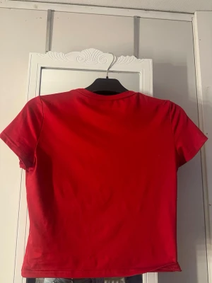 Röd croppad t-shirt i bomull - En enkel och snygg röd t-shirt med croppad passform. T-shirten har korta ärmar och rund halsringning. Tillverkad i mjuk bomull från shein i storlek L men passar mig som använder S och M upp til 