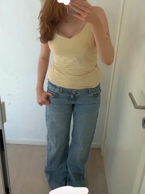 Ljusblå baggy jeans med låg midja - Säljer ett par ljusblå baggy jeans med låg midja och raka ben. Jeansen har klassisk femficksdesign och är tillverkade i denim. Från junk yard i storlek s! Endast använda 4 gånger