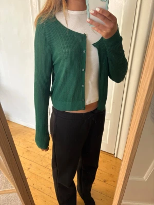 Grön ribbad kofta med knappar - Söt mörkgrön kofta från Cubus, Uniqlo! Den är i storlek m och i mycket bra skick!
