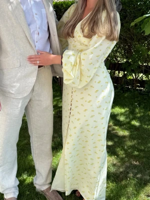 Adoore klänning  - Långklänning i ljusgul nyans med små blommiga mönster. Använd 1 gång, tvättad en gång, inga tecken på användning. Passar mig som vanligtvis ha S. 