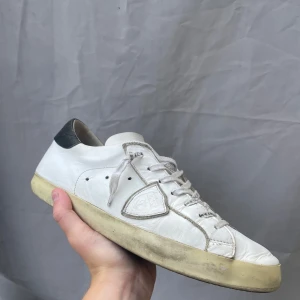 Philippe Model skor  - Vita Philippe Model skor i stl 43. De är inte lika fina som på bilderna, mycket använda, smutsigare och en liten blå fläck på höger skon.