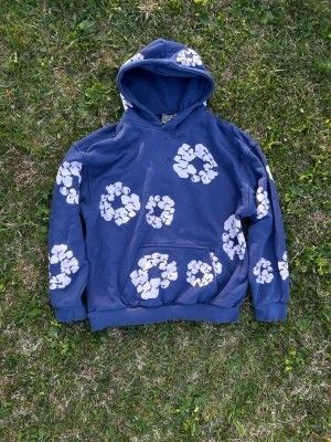 Denim tears hoodie - Säljer en blå denim tears tröja då den inte används. Den har varit använd mycket innan och den har synliga defekter som även syns i bilderna. Vet ej om äkta eller ej, men den har en tag. Pris är ej hugget i sten, skriv privat vid frågor