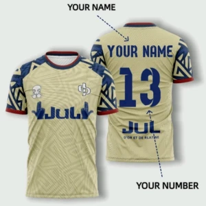 Beige fotbollströja JUL med blå detaljer - Säljer en beige fotbollströja från JUL med blå grafiska mönster på ärmarna och röda detaljer vid hals och ärmslut. Tryck på bröstet och ryggen, samt plats för eget namn och nummer. Perfekt för dig som vill sticka ut på planen.