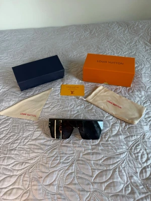 Louis Vuitton solglasögon svarta  - Säljer ett par svarta solglasögon från Louis Vuitton i otroligt fint skick, knappt använda och inte en repa finns, perfekta nu till sommar, pris och byten kan diskuteras vid snabbt köp! 
