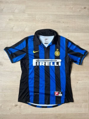 Blå Inter Milan Fotbollströja 1998/99 Ronaldo Storlek M - Mycket fin fotbollströja i blå färg. Tröjan är i mycket bra skick och sparsamt använda. |  Äkta som allt annat jag säljer! ✅ |  Storlek: M | Skick: Mycket bra Skick - Tyvärr har trycket börjat släppt på baktrycket (SE SISTA BILD) | Färg: Blå | Märke: Nike | Modell: Fotbollströja |   Hör gärna av dig vid frågor så svarar jag så fort jag kan! 😁