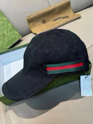 Svart keps FÖRBESTÄLLING ENDAST  - Snygg svart keps med diskret mönster i tyget och en grön-röd rand på sidan. Klassisk böjd skärm och justerbar rem bak. Perfekt accessoar för en trendig streetwear-look. Helt nytt, fraktar inom 24 timmar 