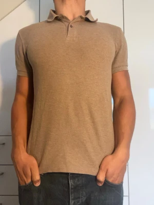 Beige piké från J.Lindberg - Beige piké från J.Lindberg tillverkad i 100% bomull. Strl S. Inga defekter. Modellen är 178 cm och väger 77 kg. Hör gärna av dig vid frågor!