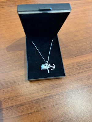 Silverhalsband med berlocker från Smycka - Snyggt silverhalsband från Smycka med tre berlocker: ett hjärta, ett ankare och ett kors. Kedjan är tunn och har små kulor. Perfekt för dig som gillar stilrena och symboliska smycken. Kommer i original ask. Ny pris 650kr 