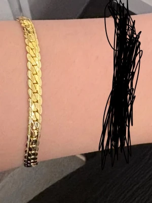 Guldarmband 18K platt kedja - Snyggt armband i 18K guld med platt, glänsande kedjedesign. Armbandet har en klassisk karbinhake och passar perfekt för dig som gillar stilrena accessoarer. Färgen är gul och materialet är äkta guld.