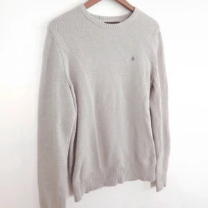 Beige/Grå stickad tröja från Morris - Säljer en stilren beige/grå stickad tröja från Morris. Tröjan har en rund halsringning och ett diskret broderat emblem på bröstet. Tröjan är i mycket bra skick ✅ Tveka inte på att ställa frågor.