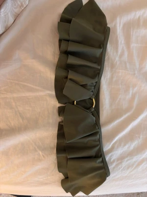 Mörkgrönt accessoarband med volang - Helt oanvänd bandå bikini med guldetalj från Nakd i jättefin grön färg, pris diskuterbart 