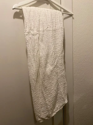 Vit långkjol i strukturerad bomull - Säljer en vit långkjol med snyggt strukturerat tyg. Kjolen har en rak passform och är gjord i mjuk bomull, perfekt för en fräsch och stilren look. Enkel att matcha med olika toppar och accessoarer.