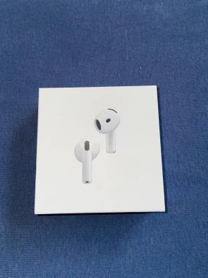 Apple AirPods 4 med brusreducering - Säljer ett par vita Apple AirPods 4 med aktiv brusreducering. Trådlösa hörlurar i stilren design med laddningsetui. Passar perfekt till dig som vill ha smidiga och moderna hörlurar i hög kvalitet. Materialet är plast och de har en klassisk Apple-look.