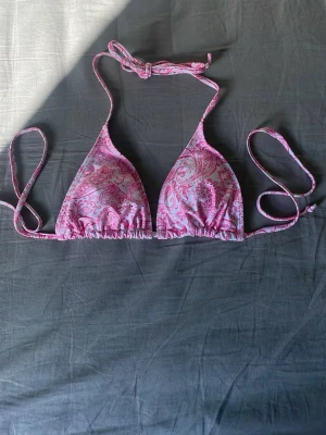 Rosa  bikiniöverdel - Snygg trekantsbikini i rosa med paisleymönster och knytband i nacken och ryggen. Perfekt för soliga dagar på stranden. 