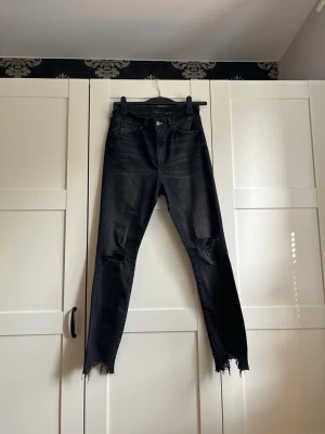 Svarta ripped jeans från Lindex  - Svarta skinny jeans med slitningar vid knäna och hög midja. Materialet är stretchigt