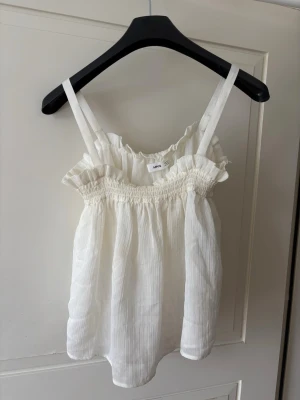 Topp från Mango - Säljer denna supersöta toppen ifrån mango😆perfekt till sommaren!🌸den har en liten liten ”prick” som inte går bort tyvärr (sista bilden) men annars är den fin & i bra skick! 