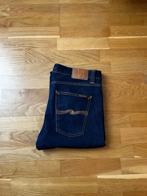 Nudie jeans Dry 16 dips - Säljer ett par nästan helt nya nudie jeans Dry 16 dips. Det är rådenim alltså unwashed, vilket betyder att jeansen kommer att utveckla unika fades och slitningar beroende hur du använder dem och din livsstil. Storleken är 34/34 men är lite små i storleken. Midjan: 44 cm. Innerbensmått: 72 cm. Perfekt för dig som vill bryta in ett par egna jeans och få riktigt snygga och personliga fades. Priset är inte spikat i sten så kom med förslag! Hör av dig vid frågor eller intresse!!