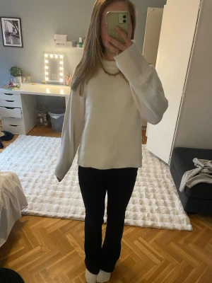 Vit stickad tröja  - Mysig vit stickad tröja med rund halsringning och avslappnad passform. Tröjan har långa ärmar och ribbade muddar vid halsen. Perfekt att matcha med jeans eller kjol för en enkel och stilren look.