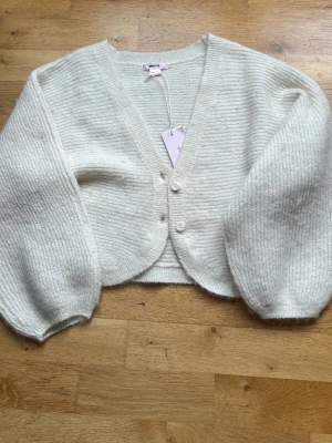 Vit stickad kofta  - En fin stickad vit kofta från Gina tricot young, den är lite kortare i modellen och är i storlek 146/152💕 den är helt ny och aldrig använd och har kvar prislappen!