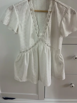 Vit spetsblus med v-ringning - Söt vit blus med djup v-ringning och spetsdetaljer längs urringningen 💗