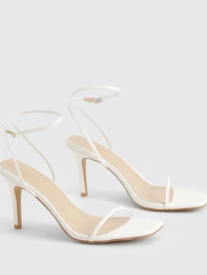 Vita strappy pumps från Boohoo - Säljer ett par vita pumps från Boohoo. Skorna har en elegant ankelrem med spänne och en smal klack. Tillverkade i syntetmaterial med en stilren och minimalistisk design.
