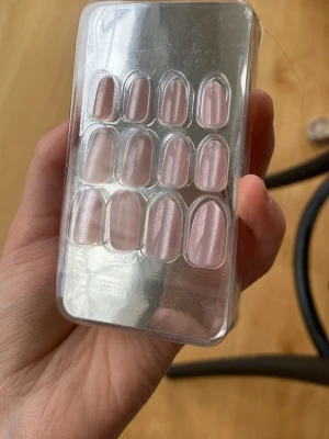 Ljusrosa lösnaglar i oval form - Ett set med ljusrosa lösnaglar i oval form. Naglarna har en glansig finish och kommer i olika storlekar för att passa alla fingrar. Perfekt för dig som vill fixa snygga naglar snabbt och enkelt hemma.Har typ aldrig använt 