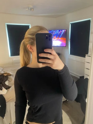 Svart långärmad topp i ribbad bomull - En enkel och stilren svart långärmad topp med rund halsringning. Toppen är ribbad och har en croppad passform😊