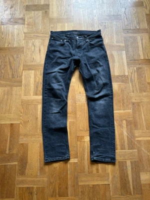 Nudie jeans - Tjena, säljer dessa mörk grå nudie jeans, modell grim tim, storlek 30/30. Används en del och har två lagningar som är gjorde av nudie repair shop. Fråga på!  Längd: ca 97,5cm Bredd: ca 40cm Benöppning: ca 16cm