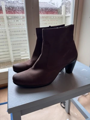 Bruna mockastövletter med klack - Jättefina bruna stövletter i mocka med rundad tå och medelhög klack från Ecco. Dragkedja på insidan för enkel på- och avtagning.