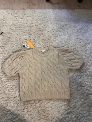 Beige tröja med puffärm - Jättesöt tröja från Gina Tricot med puffärm, aldrig använd men har tyvärr lite dragen tråd i mitten , annars i väldigt bra skick!