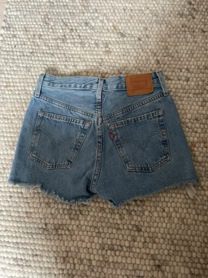 Levi's jeansshorts - Säljer ett par klassiska blå jeansshorts från Levi's i storlek 23W.