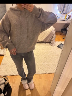 Grå beige stickad hoodie - Mysig stickad hoodie med huva. Färgen är grå men lite beige sktig och bomull. Även Stor i passformen