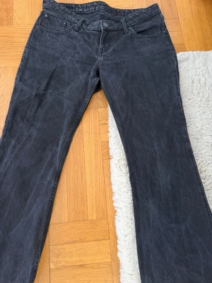 Svarta bootcut jeans  - Säljer ett par svarta bootcut jeans och klassisk femficksmodell. Jeansen har normal midja och vida ben, perfekta för en avslappnad och trendig stil. Materialet är denim i bomull och de har bälteshällor. Dom är missfärgade pågrund av tvättning och är också uppsydda vid benen men går lätt att sprätta upp💕